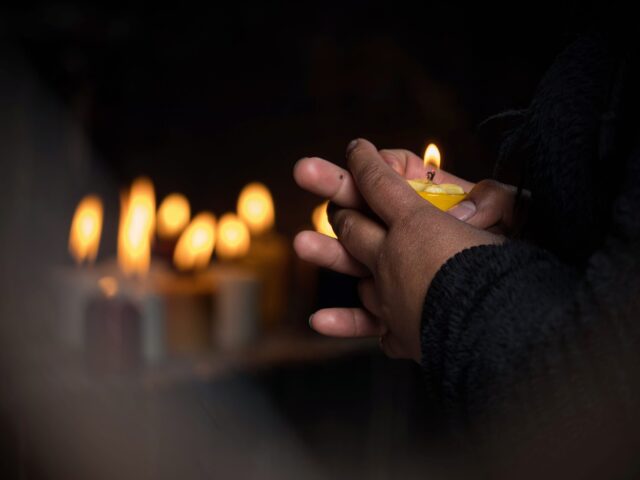 Woman,Holding,Yellow,Burning,Wax,Candle,In,Her,Hands,Memorial