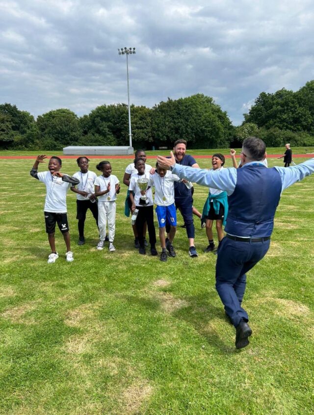 Pupils, coach and CEO celebrating athletics win