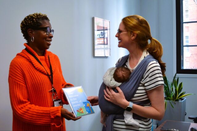 L-R registrar Alma delivers share and read baby pack to new mother Caroline