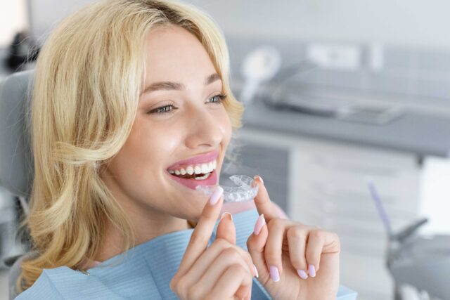 young-attractive-woman-holding-invisible-braces
