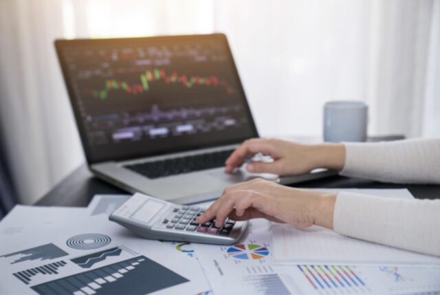 Investor analyzing financial charts and calculating portfolio risk