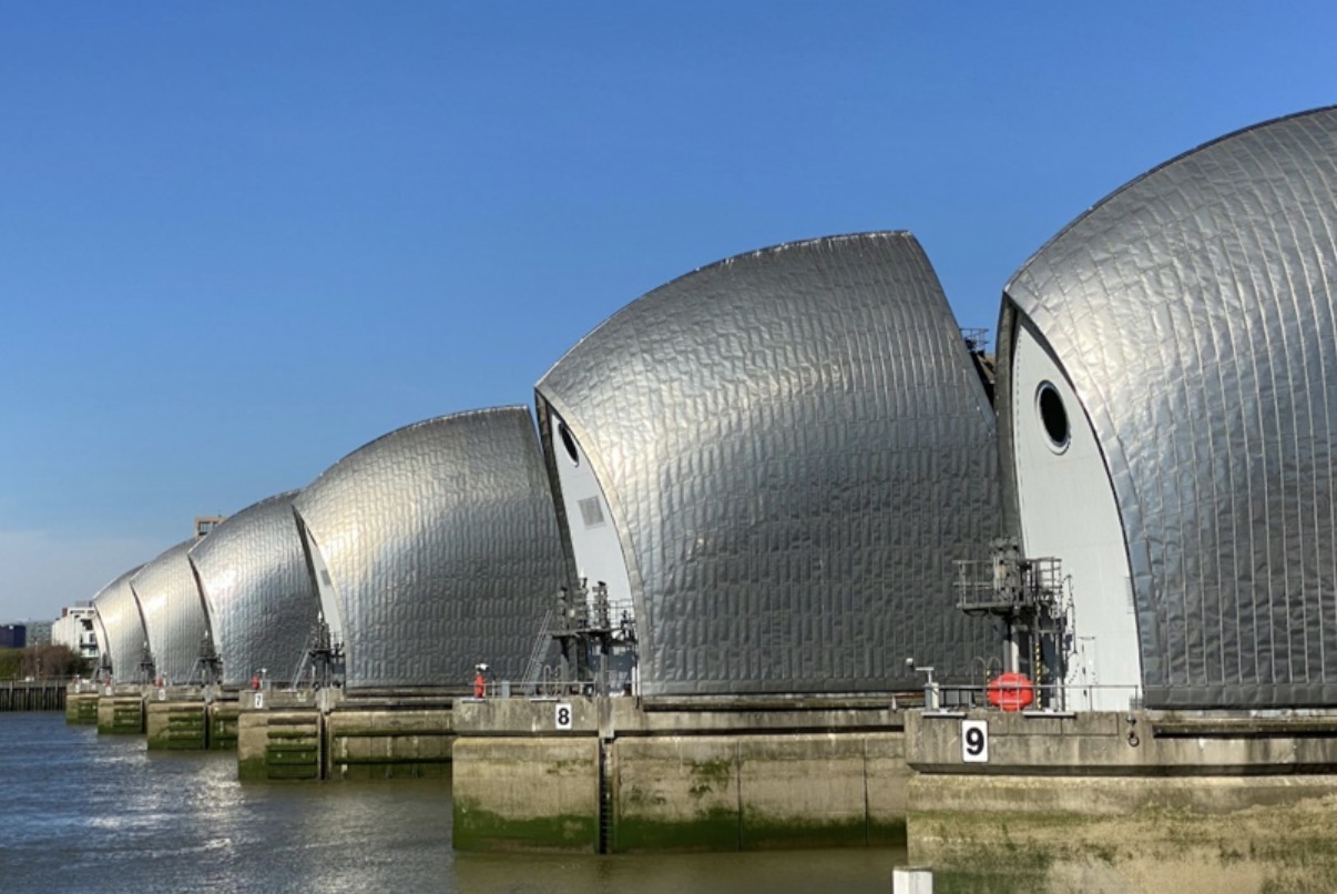 The steel gates of the Thames Barrier rising from the River Thames under a clear sky